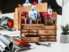 An image where a hand is carefully placing a bottle on one of the organizer's shelves.