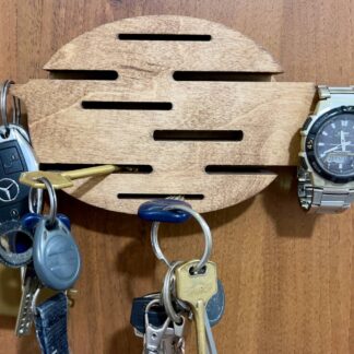 A side-profile shot of the wooden key holder, showing its thin, sleek construction and the smooth, natural wood grain.