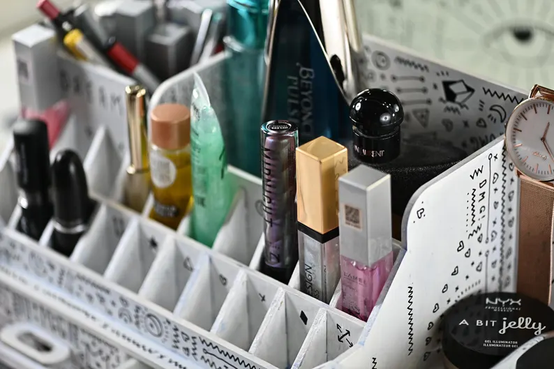 A lifestyle photo of the organizer on a high-end vanity, with a mirror and other luxurious decorative items in the background.