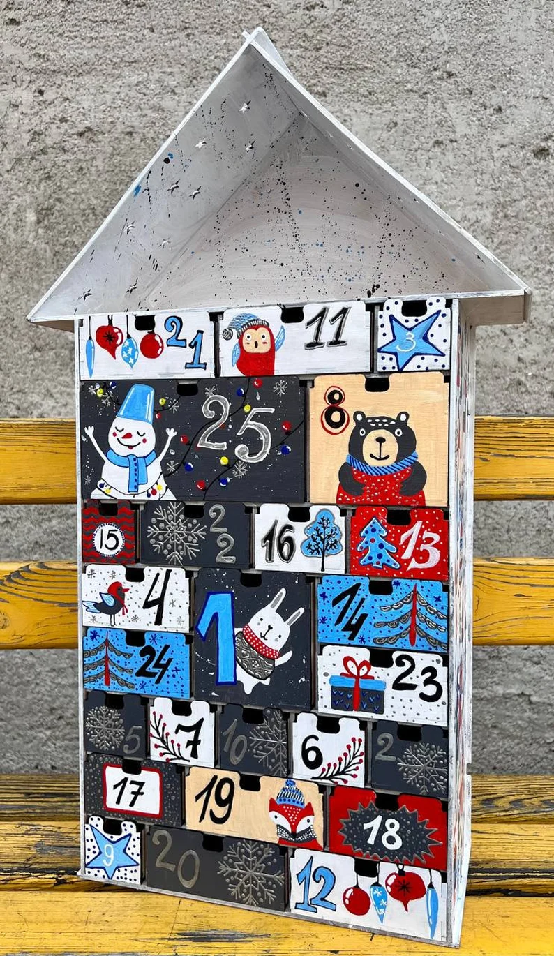 A lifestyle photo of the calendar on a wooden table in a festive room setting.