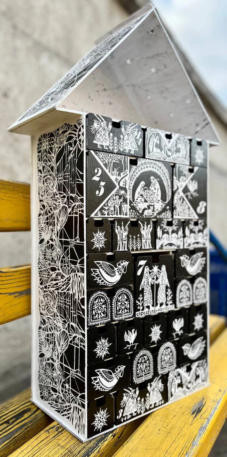 A top-down view of the wooden cutlery organizer placed in a kitchen drawer, filled with silverware.