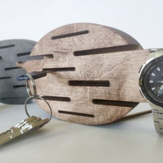 A lifestyle shot showing a hand placing a key on one of the hooks of the wall-mounted organizer.