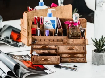 An image where a hand is carefully placing a bottle on one of the organizer's shelves.
