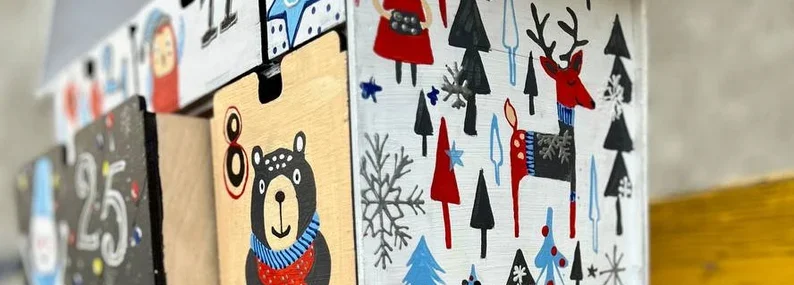 A close-up shot of several of the small, numbered drawers on the advent calendar, some of which are slightly open.