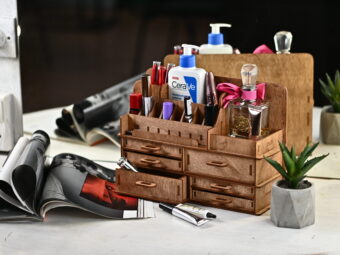 A close-up shot of a hand placing a lipstick into one of the compartments.