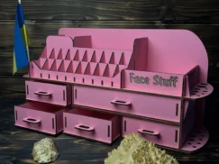 A flat lay image of the pink organizer on a clean surface with some cosmetic products scattered around it.