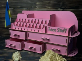 A flat lay image of the pink organizer on a clean surface with some cosmetic products scattered around it.